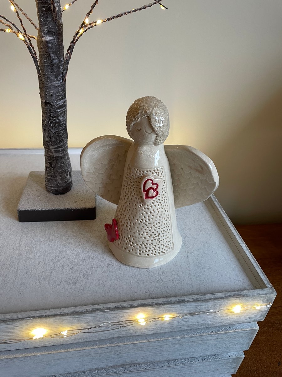 Ceramic angel sculpture with red entwined hearts and butterfly 