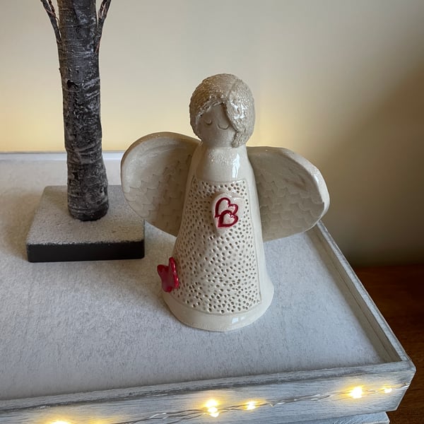 Ceramic angel sculpture with red entwined hearts and butterfly 