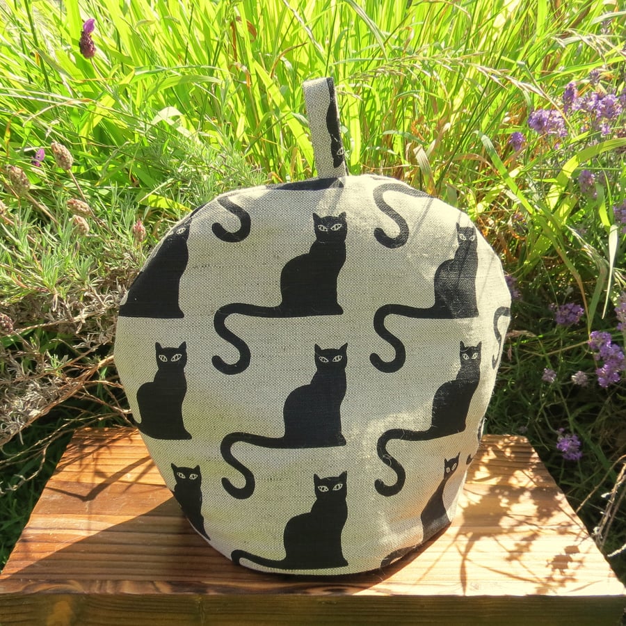 A whimsical black cat tea cosy.  To fit a 2 - 3 cup teapot.