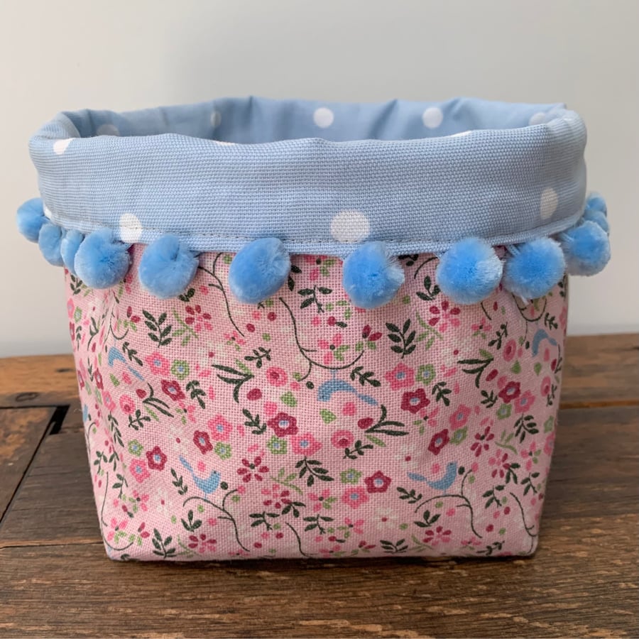 Pink and blue storage basket with pompoms
