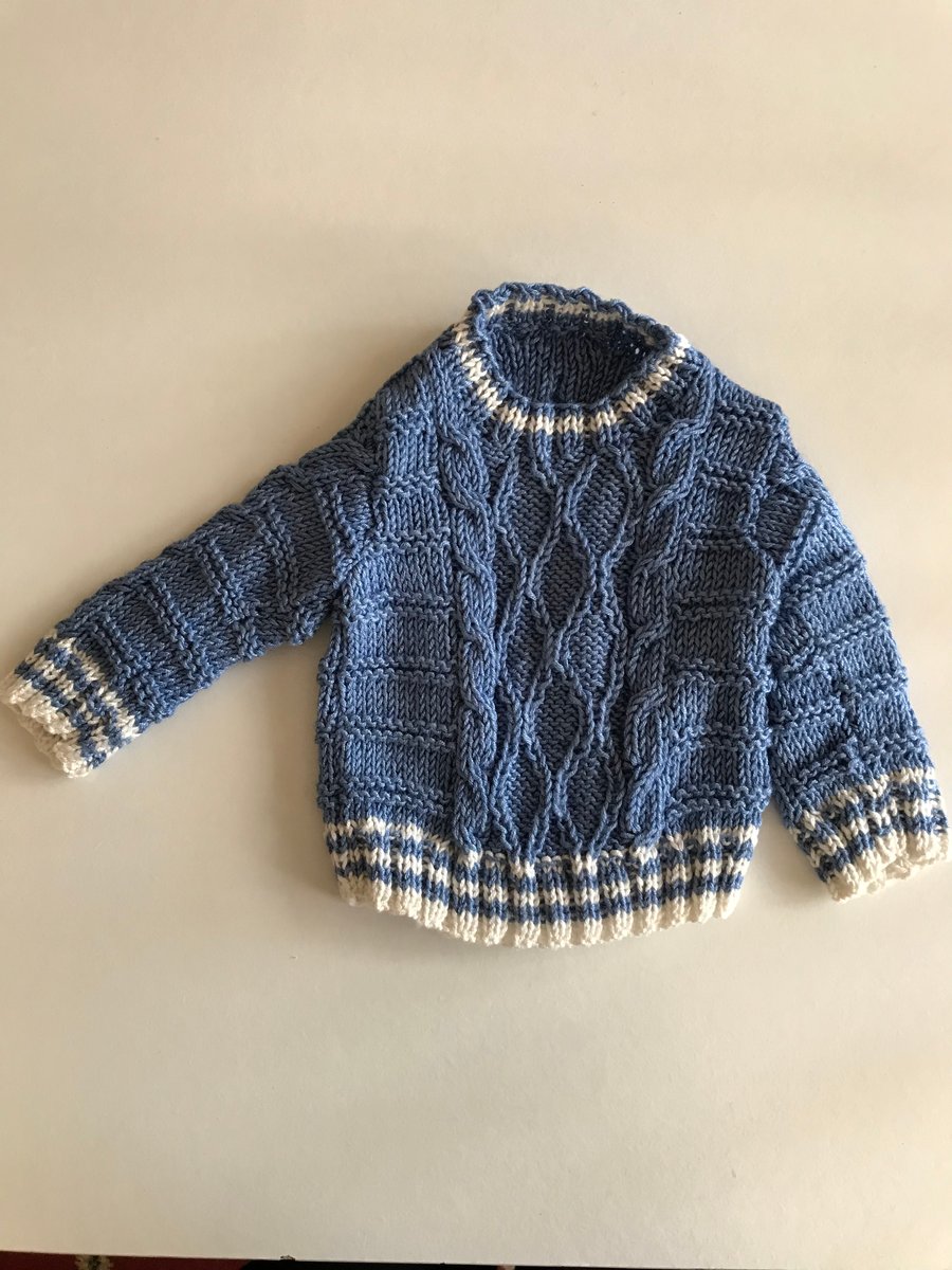 Patterned hand knitted baby jumper in natural fibres yarn