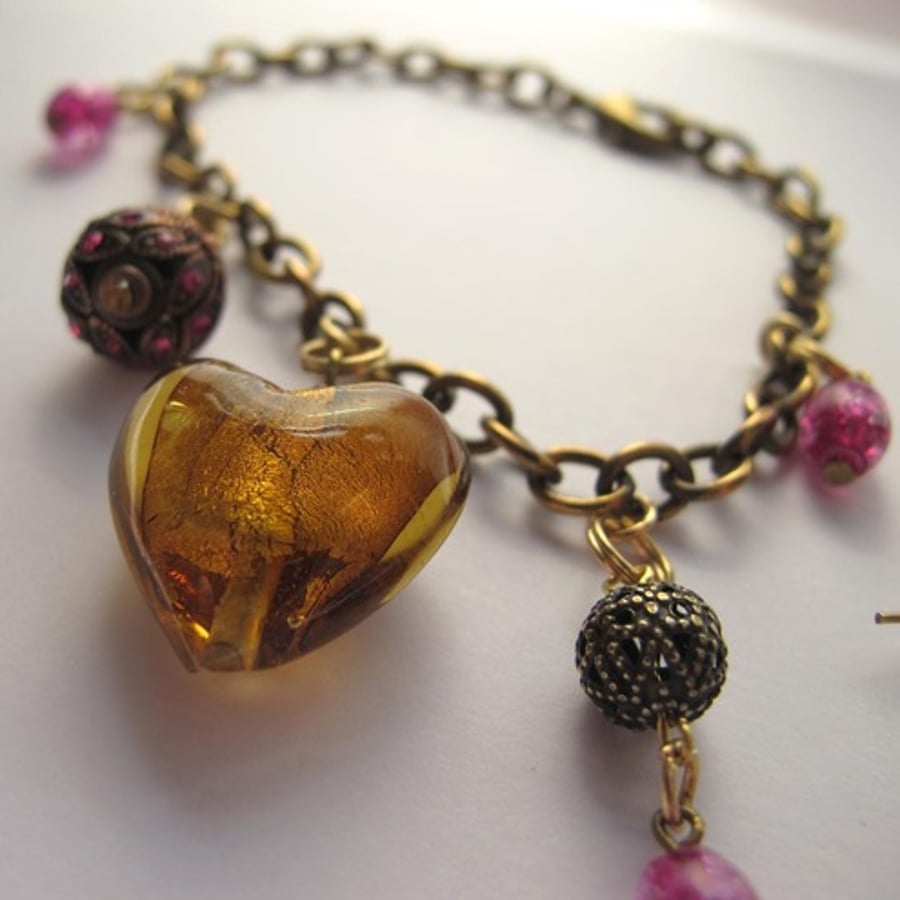 Unusual charm bracelet and earrings with pink and gold beads 