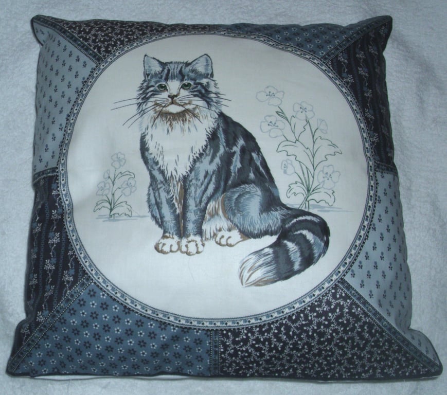 A very pretty grey and white fluffy cat cushion