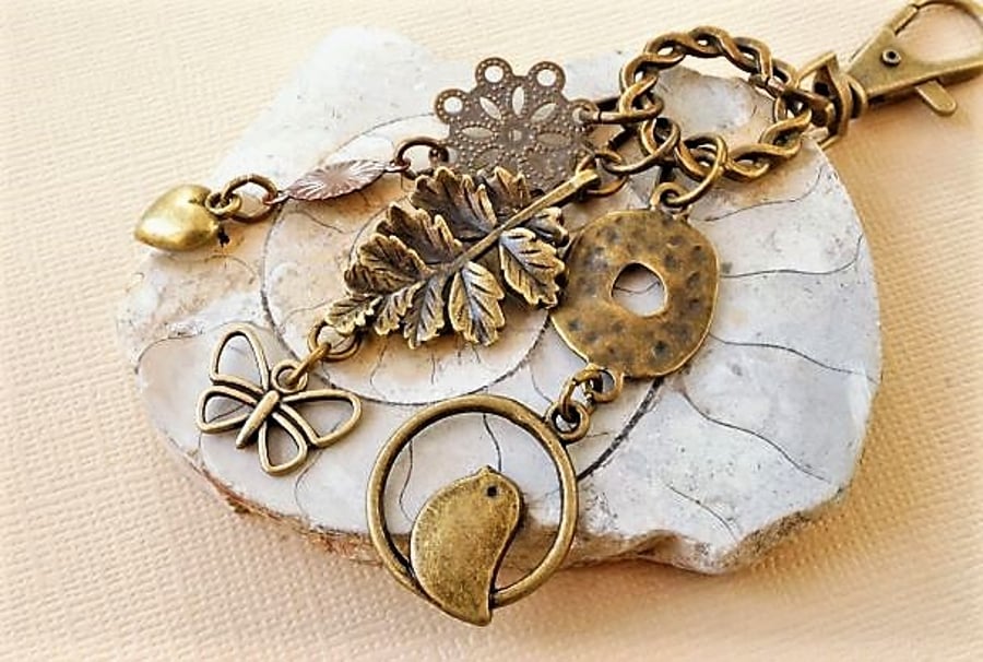 Antique bronze bag charm with leaf butterfly bird and heart
