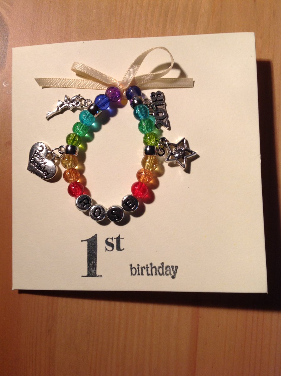 Stretch bracelet, hand strung, with charms attached, on a greetings card.