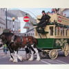 Photographic greetings card of two horses pulling an open top bus.