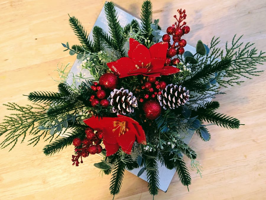 Christmas table centrepiece with red poinsettia and pine cones table decoration