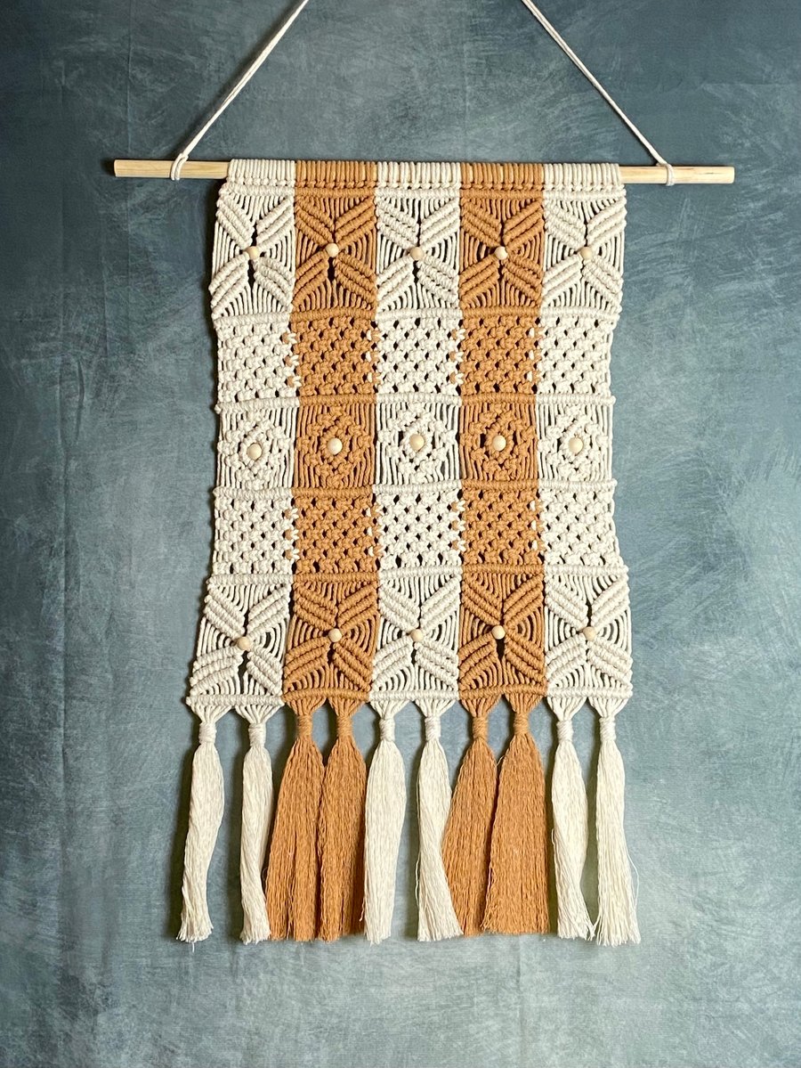 Macrame wall hanging with intricate knot design, caramel and beige colours
