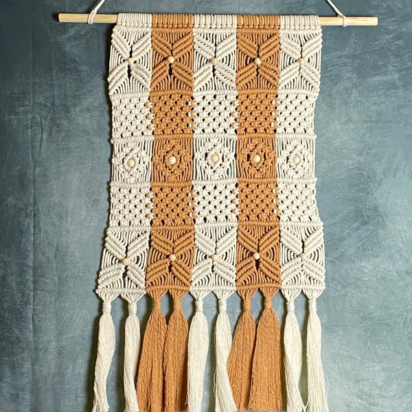 Macrame wall hanging with intricate knot design, caramel and beige colours
