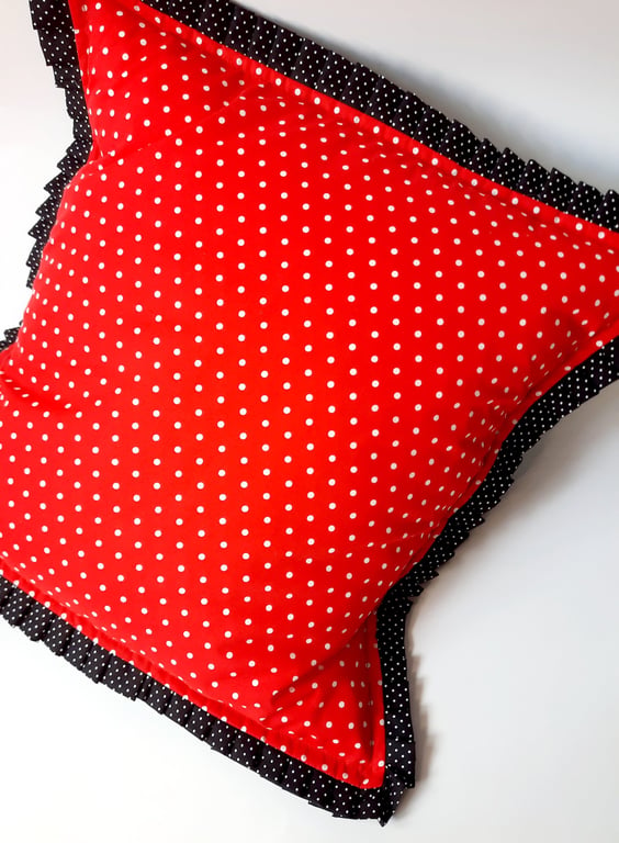 Red polkadot cushion cover with black polkadot pleated edge.