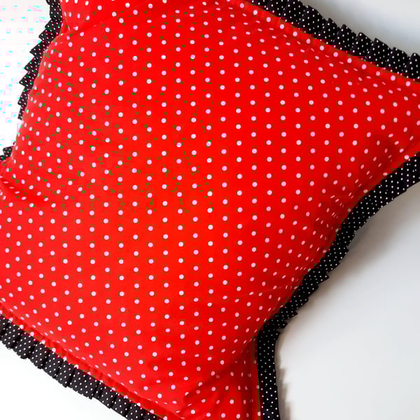 Red polkadot cushion cover with black polkadot pleated edge.