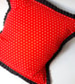 Red polkadot cushion cover with black polkadot pleated edge.