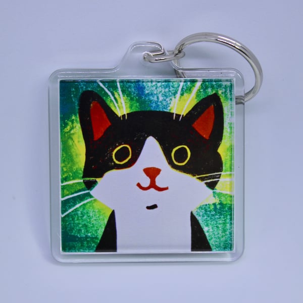 LITTLE BLACK AND WHITE HAPPY CAT KEYRING WITH GREEN BACKGROUND