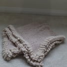 Very Soft Cream Baby Blanket with pom pom edging.