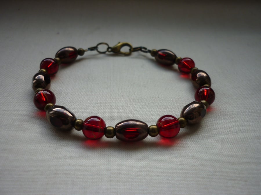 BRONZE & RED BRACELET.  1099