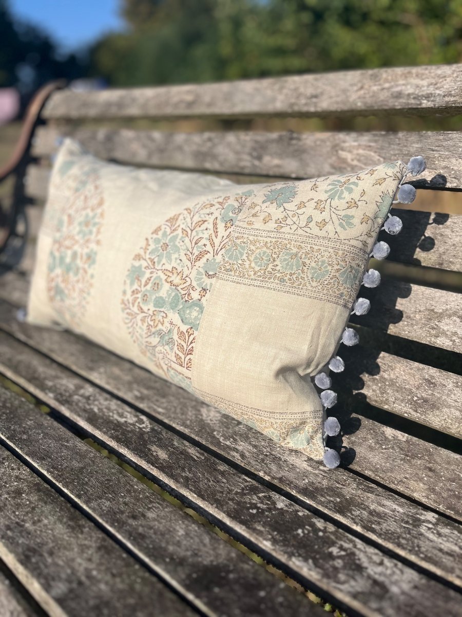 Long linen feature cushion with pompom trim