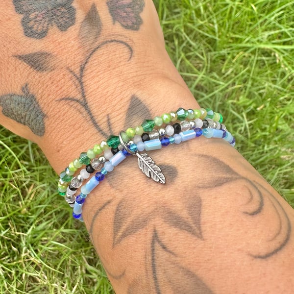 Beaded elasticated bracelets with hanging feather charm