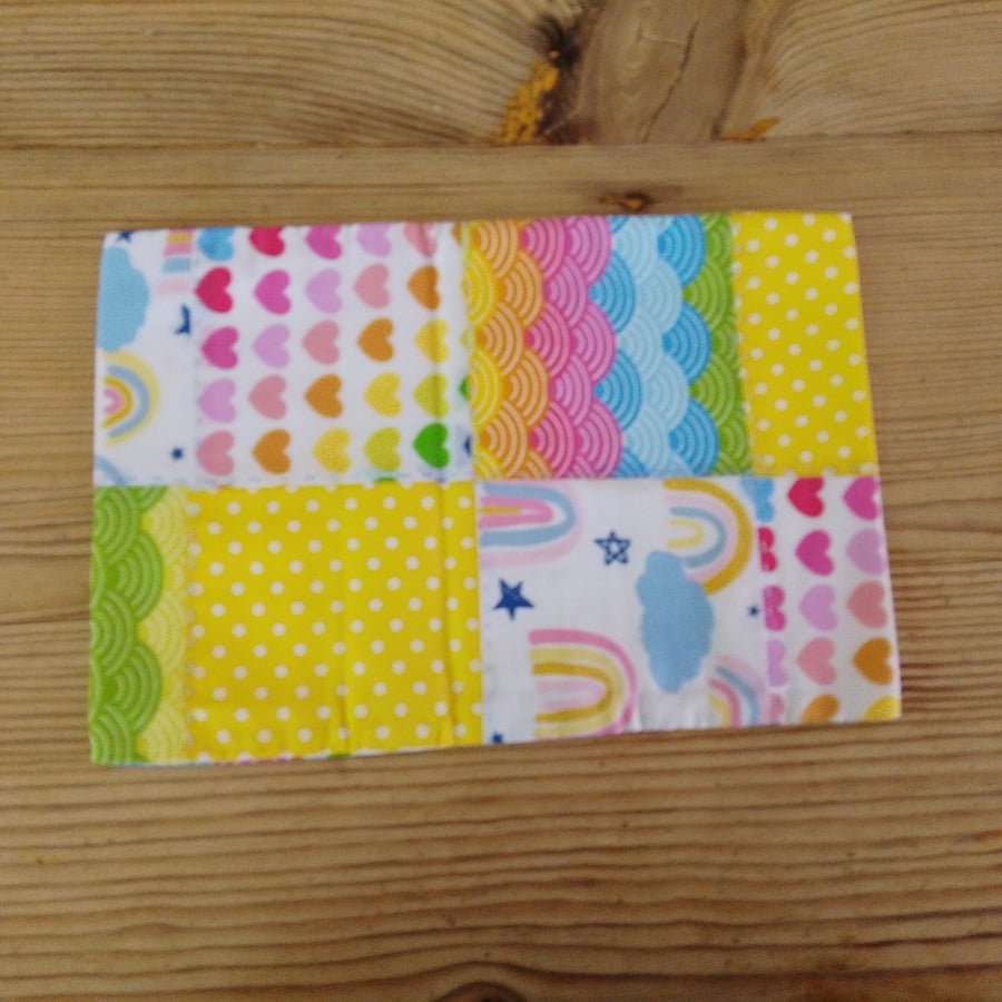 Cushion cover made from bright rainbow theme fabric with envelope closure.
