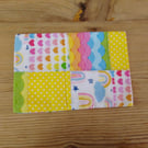 Cushion cover made from bright rainbow theme fabric with envelope closure.