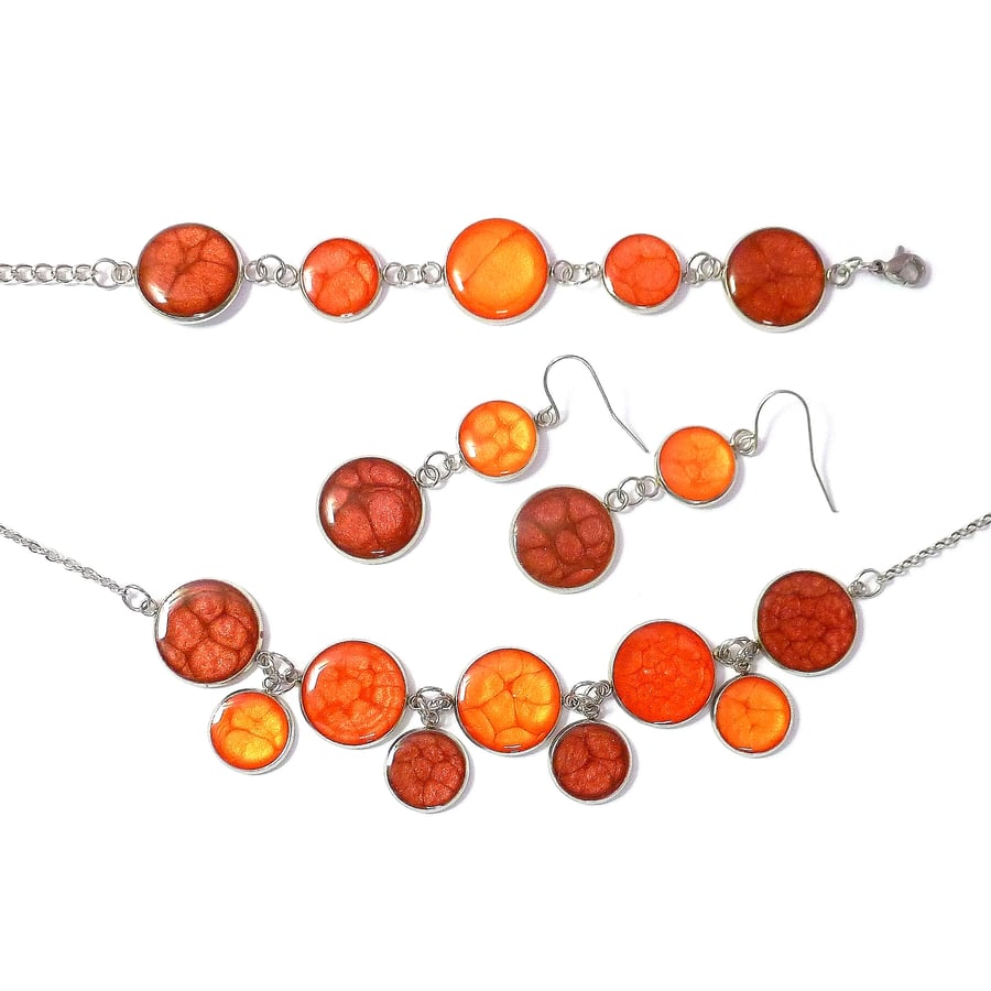 Red jewellery set. Earrings, bracelet and necklace in red and orange enamels