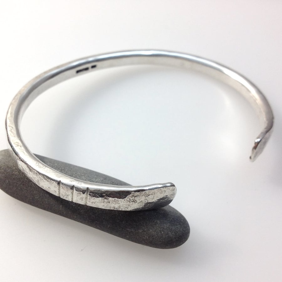 Heavy oval silver open bangle with notched detail