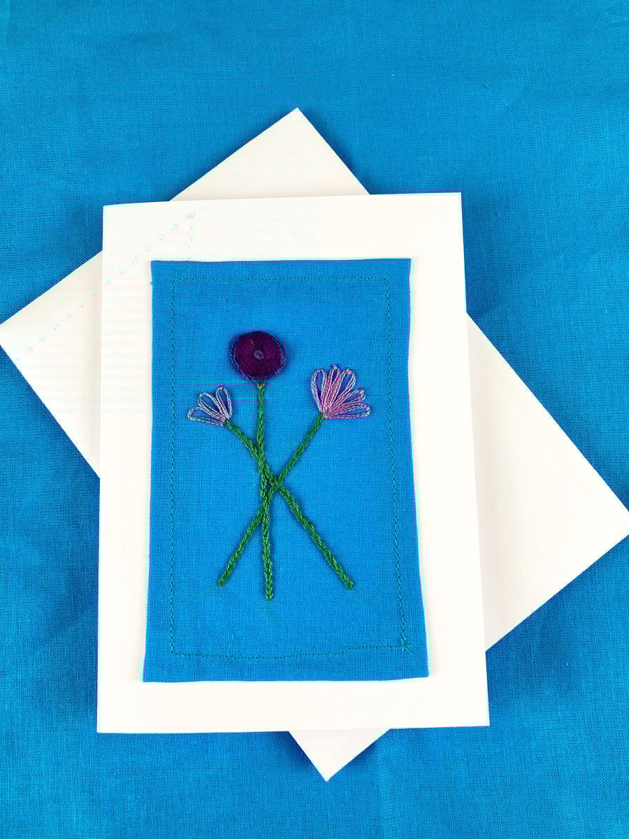 A trio of purple flowers embroidered card.
