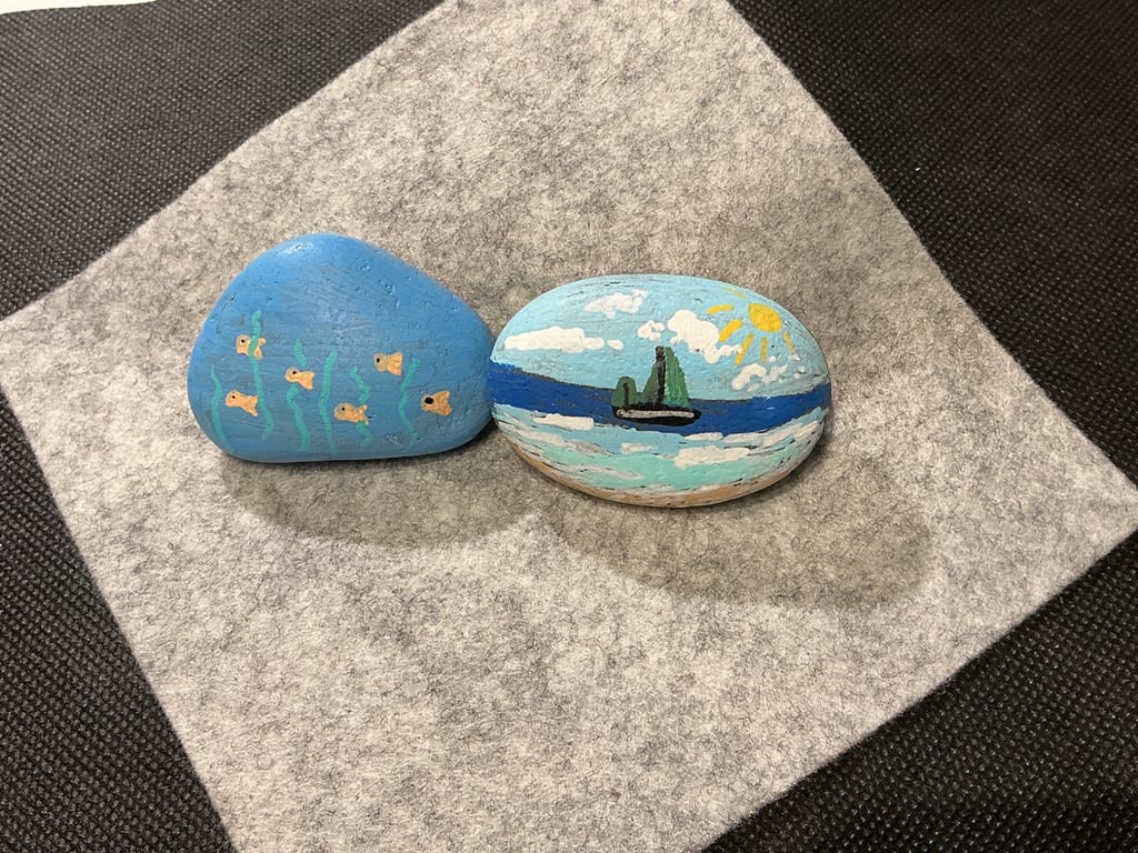 Set of 2 hand painted pebbles with sailing and seaside theme.