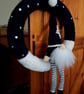 Festive crocheted wreath with gonk and snowflakes