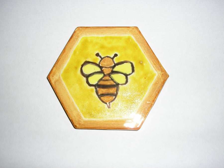 A BEE HANDPAINTED ON TO A CERAMIC HEXAGONAL TILE 9.5.cms x 9.5 cms