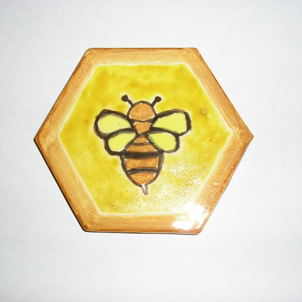 A BEE HANDPAINTED ON TO A CERAMIC HEXAGONAL TILE 9.5.cms x 9.5 cms