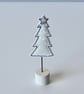 A Christmas Tree in a Painted Wooden Stand