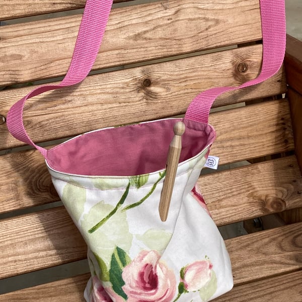 Pretty, floral peg bag with pink shoulder strap. Traditional rose design.