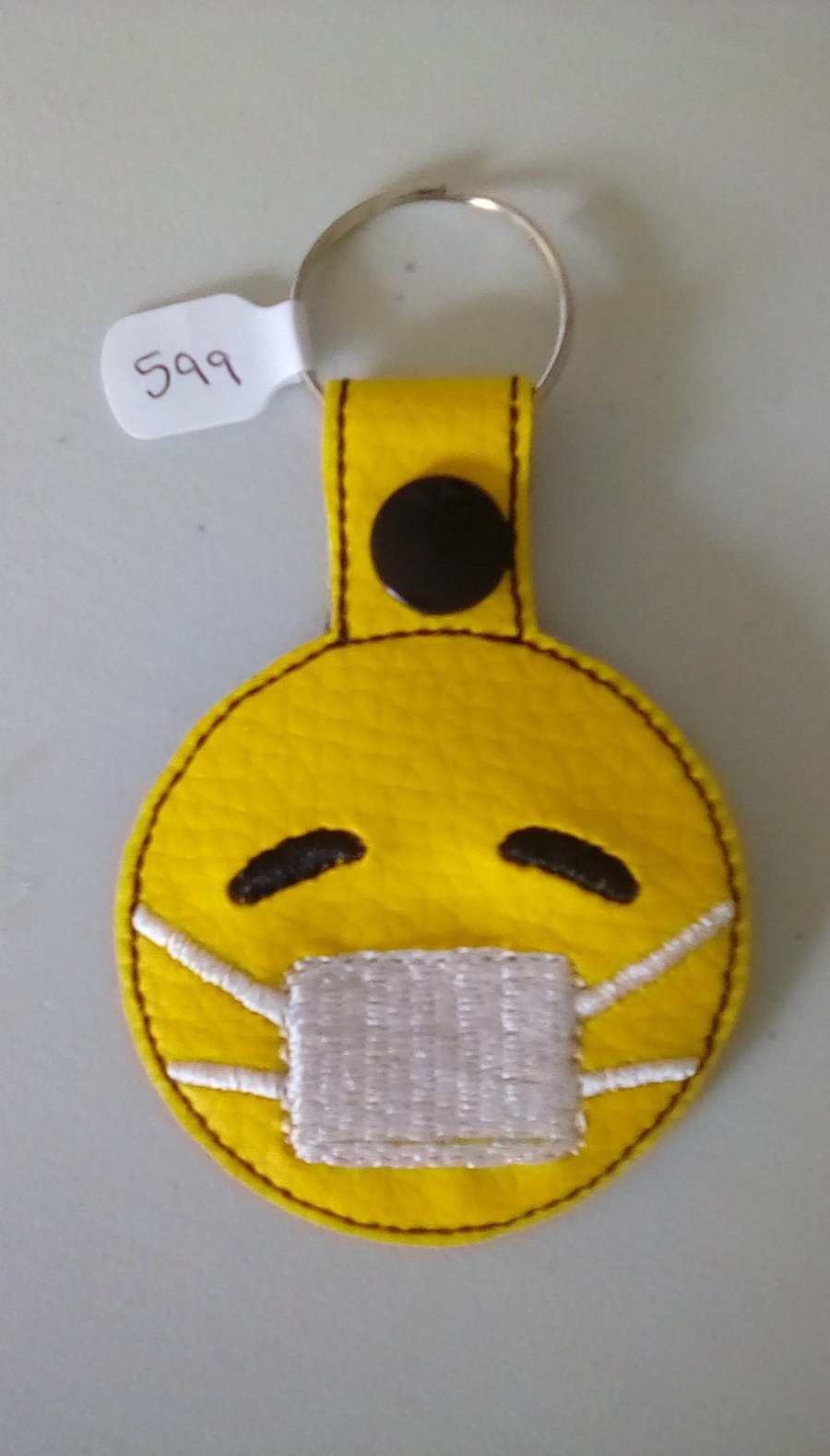 599. Face mask emoji keyring.