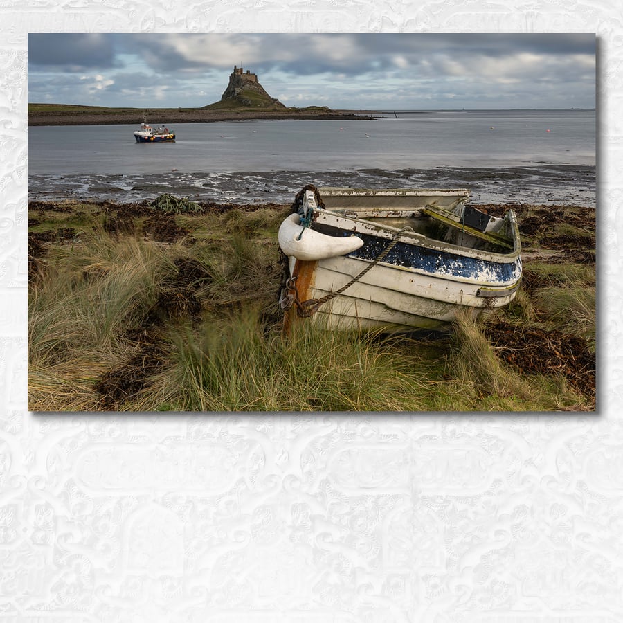 Weathered boat on Lindisfarne with castle in the background, Northumberland