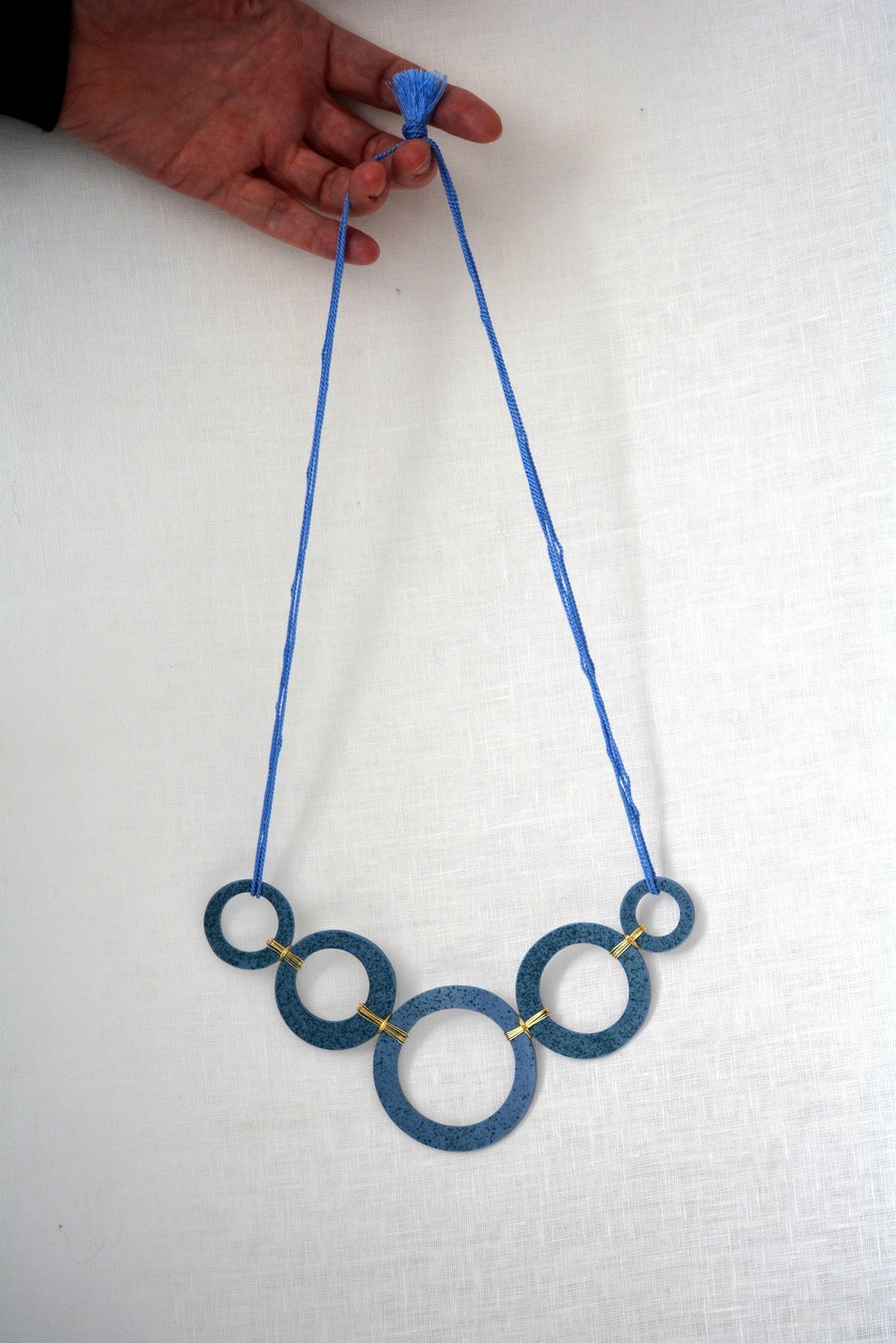 Blue porcelain with green speckles necklace with gold colour plated wire