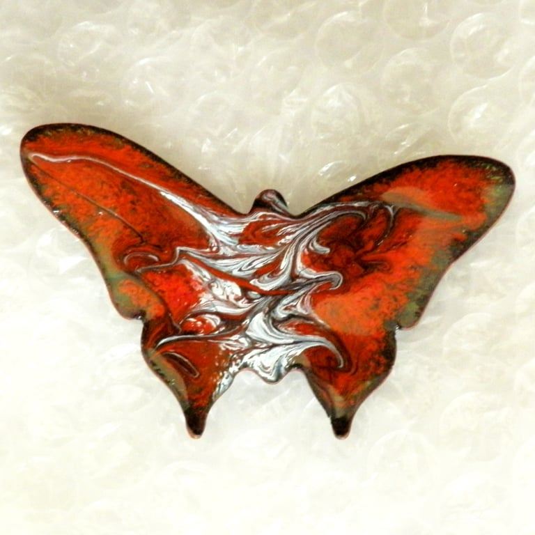 large butterfly brooch, scrolled white and grey on red over clear enamel
