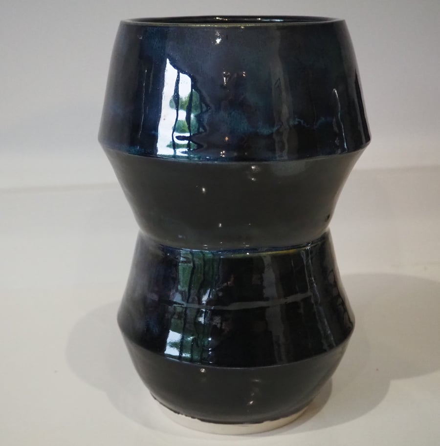Ceramic tall angular black vase with blue, green accents. 