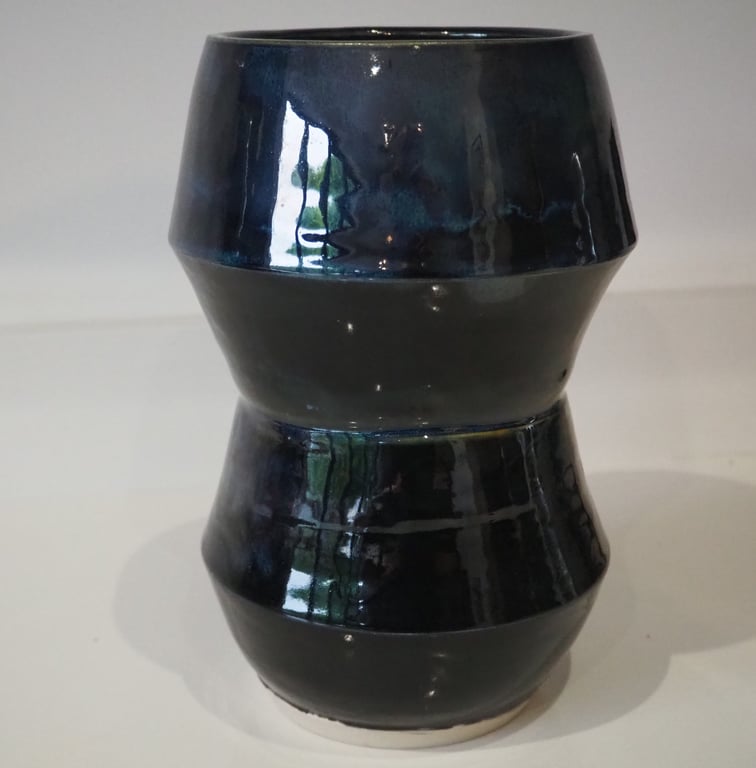 Ceramic tall angular black vase with blue, green accents. 