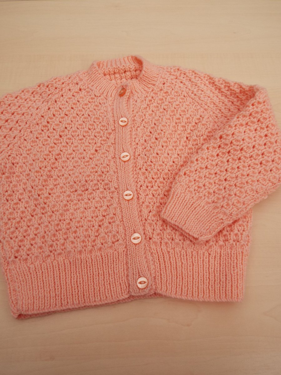 Girls cardigan hand knitted in peach yarn to fit 3 - 4 years