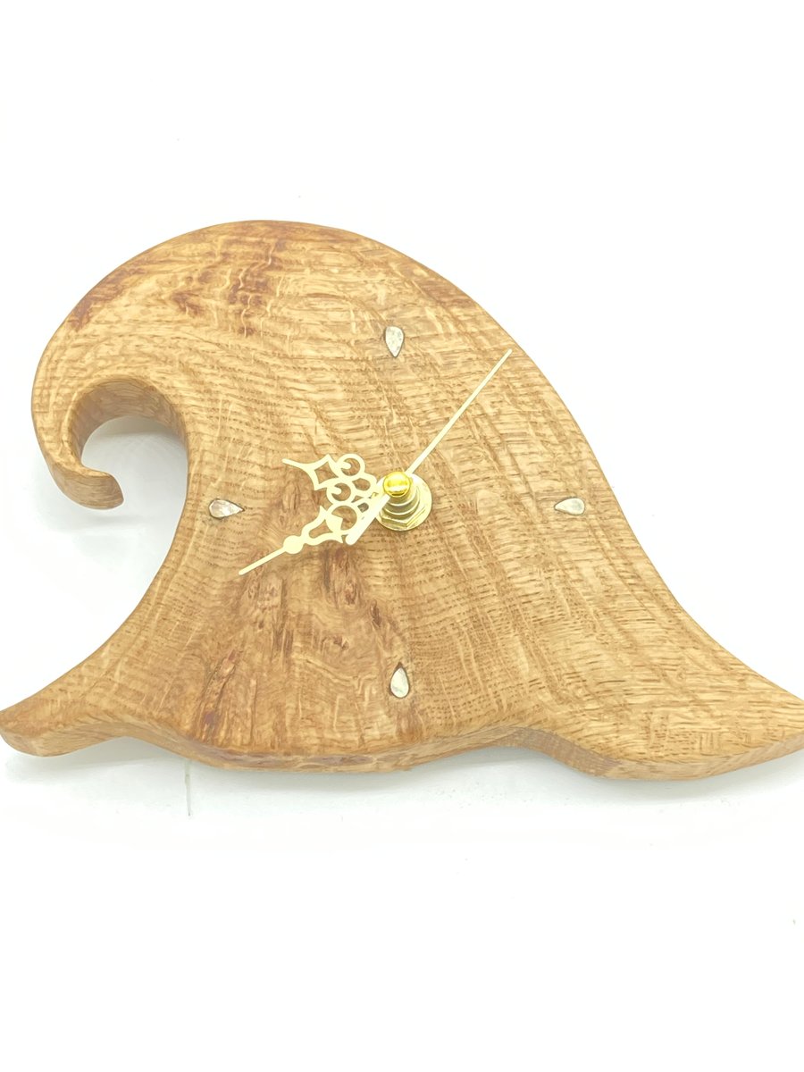 Small hand carved oak 'wave' clock with mother of pearl quarter marks.