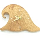 Small hand carved oak 'wave' clock with mother of pearl quarter marks.