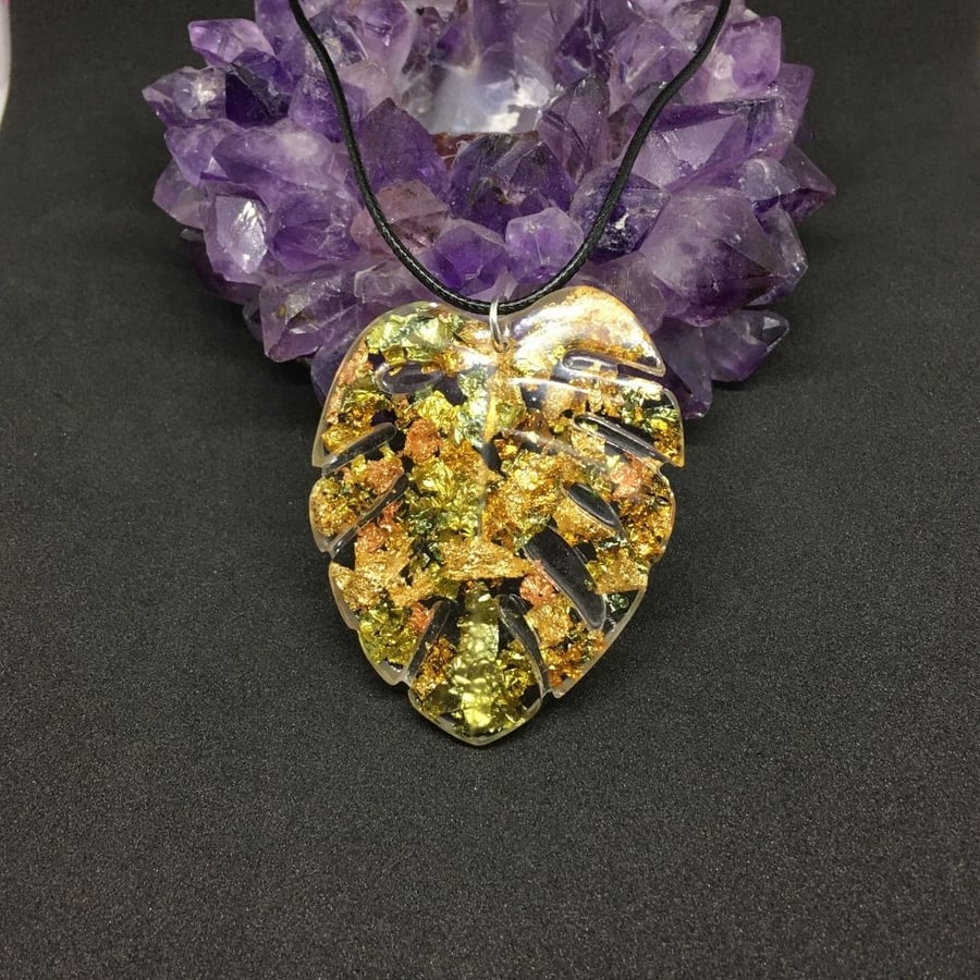 Sale, Monstera leaf metallic pendant with a black cord chain.