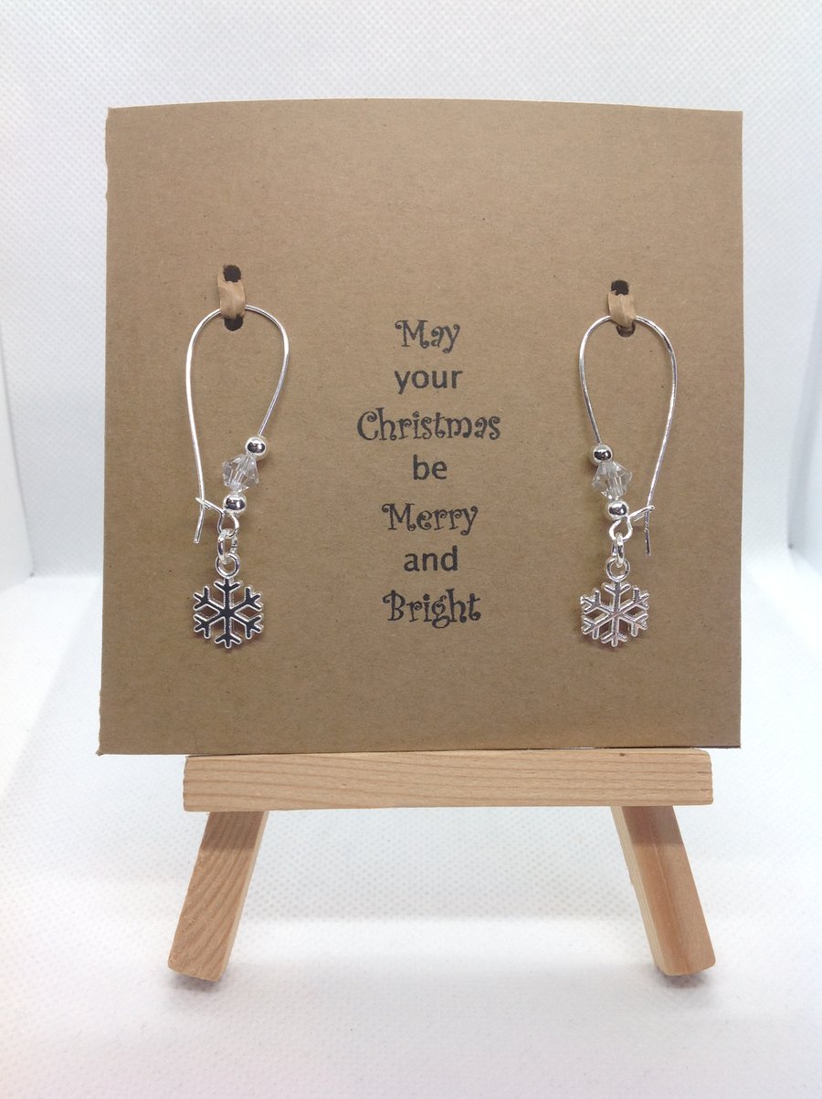 Hand made snowflake earrings on a greeting card