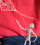 figure made out of wire flying a kite 