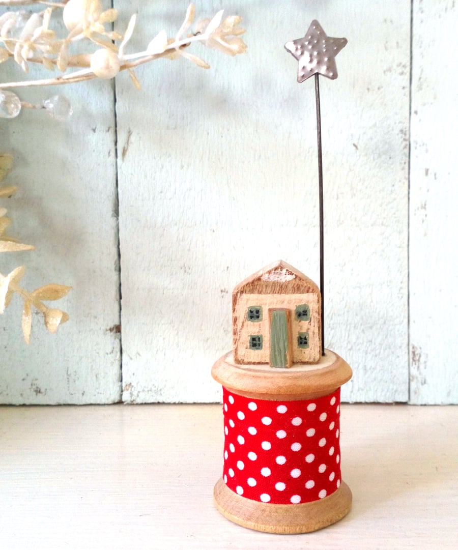 Little wooden house with Christmas star on vintage bobbin