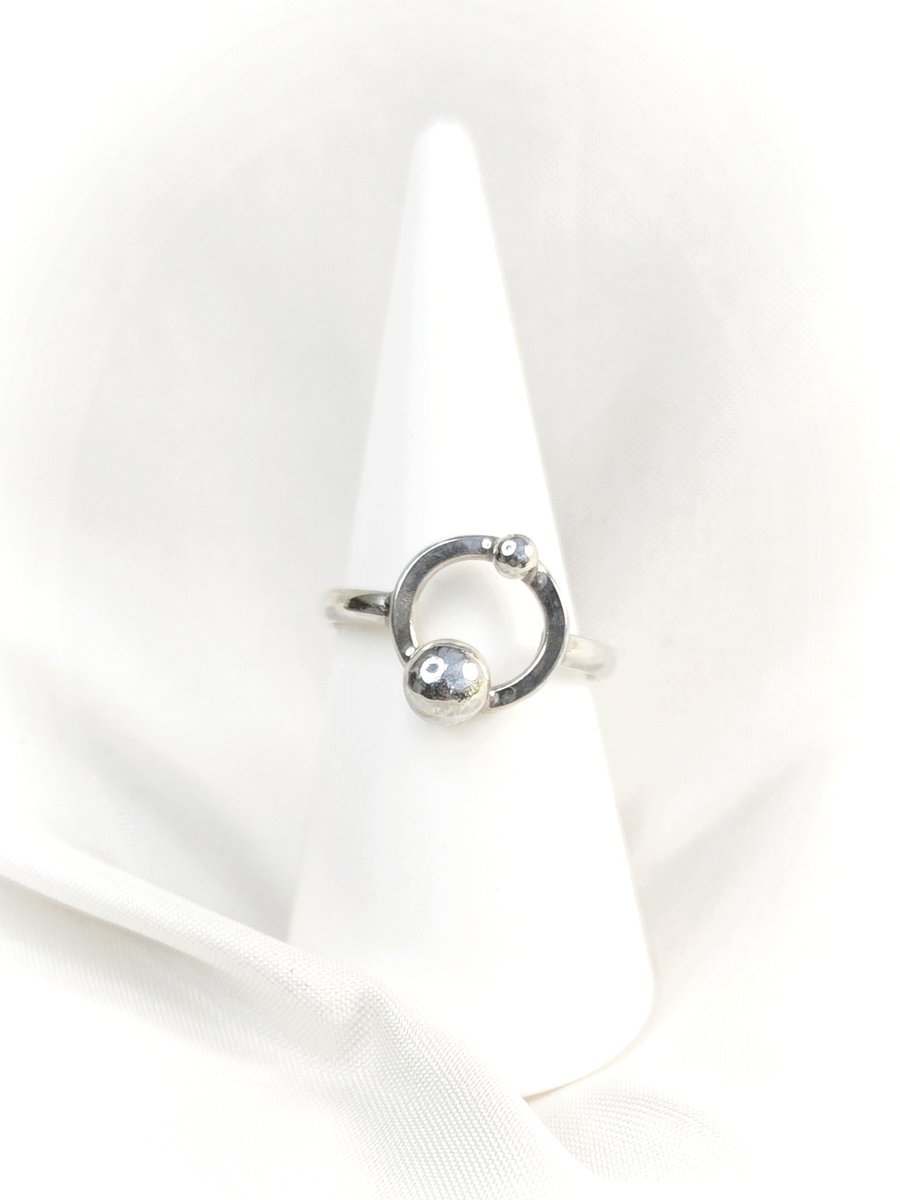 Silver ring with orbiting pebbles