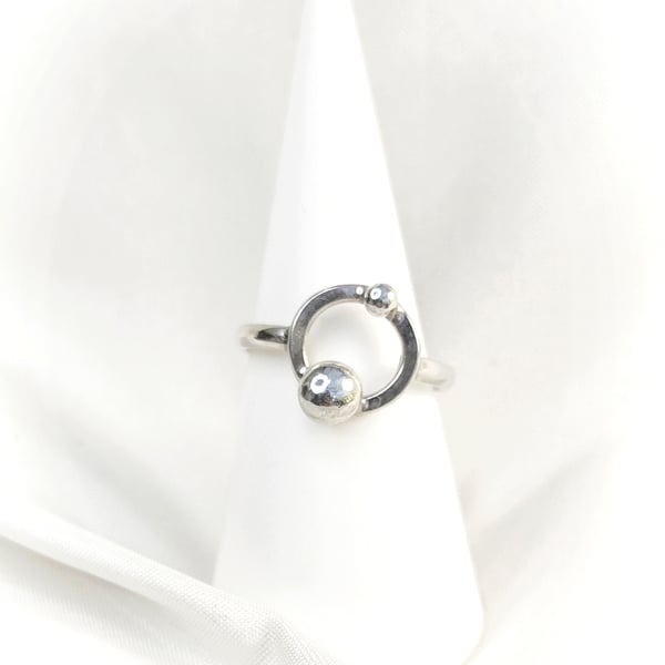 Silver ring with orbiting pebbles