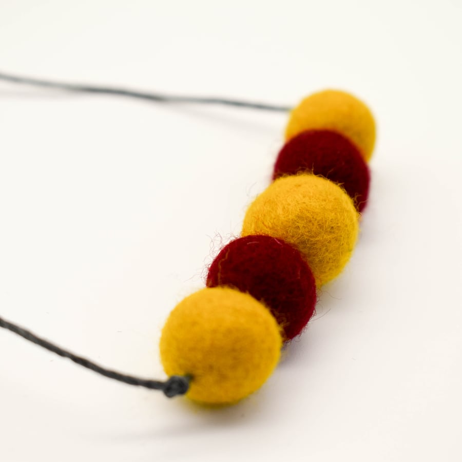Felted bead necklace in red and ochre yellow wool