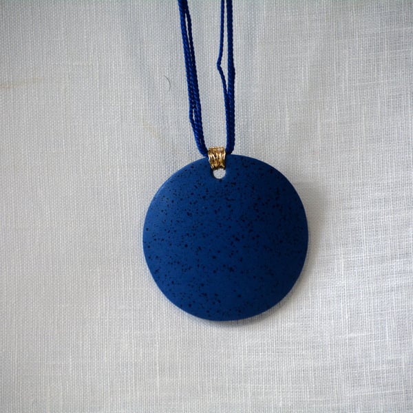 Speckled blue hue porcelain pendant with gold colour plated wire 