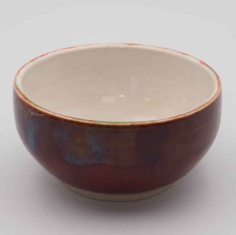 Stoneware Japanese inspired tea bowl, red with blue accents.